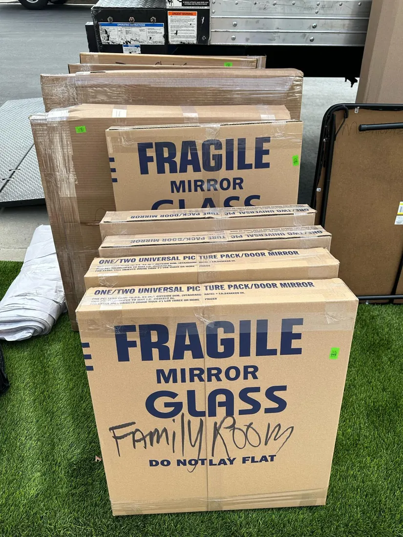 Mirror and glass boxes packed and labeled Fragile, Family Room, next to a Presto truck