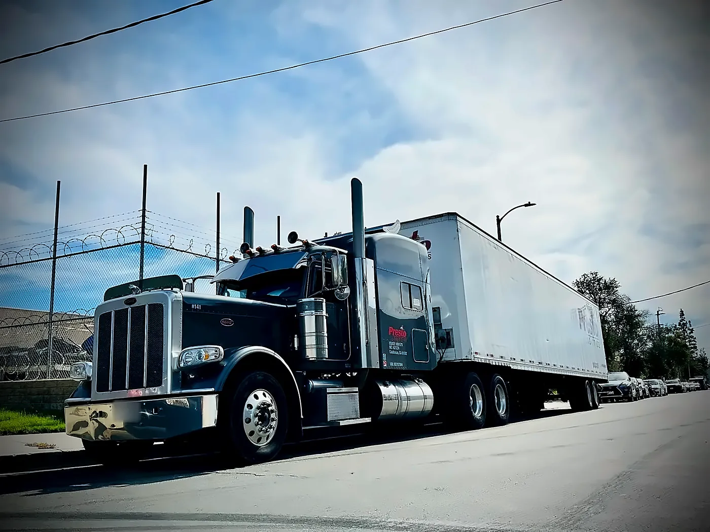 Presto Logistics tractor-trailer, truck 141, with long-haul sleeper cab parked on a street