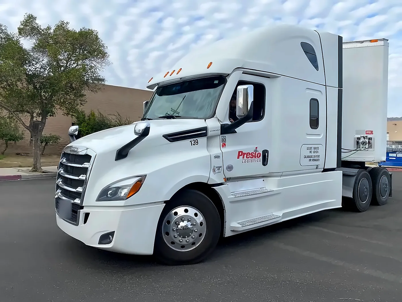 Presto Logistics truck 139 with a white moving trailer, company logo and USDOT number on the door
